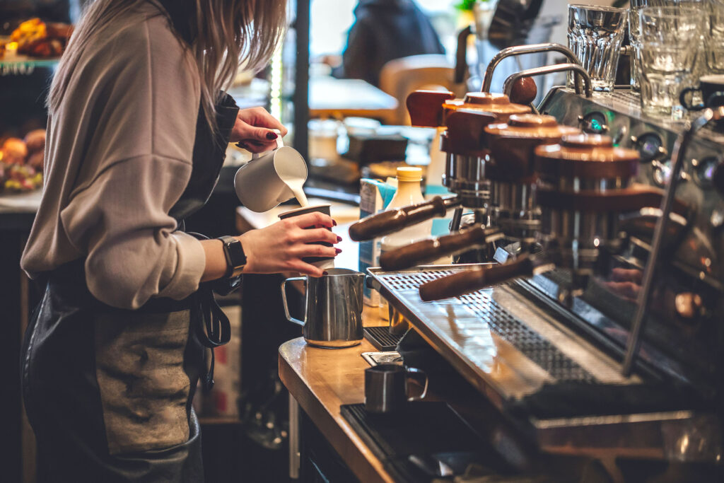 barista making cappuccion coffee in coffee shop