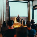 Speaker engages an audience during a business seminar in a modern conference room.